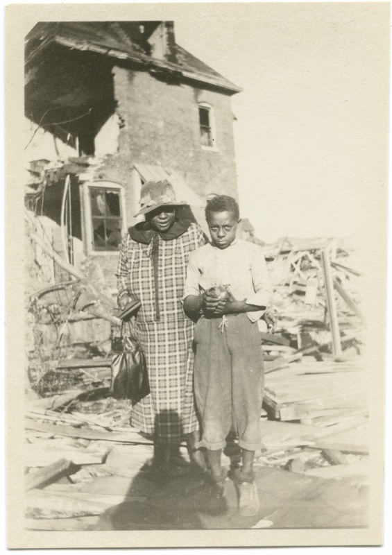 Woman and Boy in Front of Tornado Damaged Home