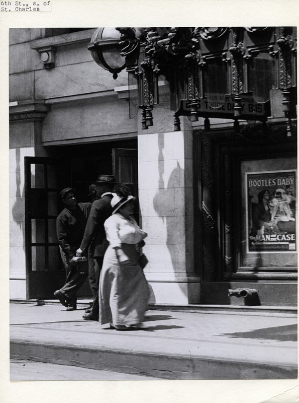 Woman Passing a Group of Men on The Sidewalk in Front of the Strand and Columbia Theaters At 419 And 425 North 6th Street.