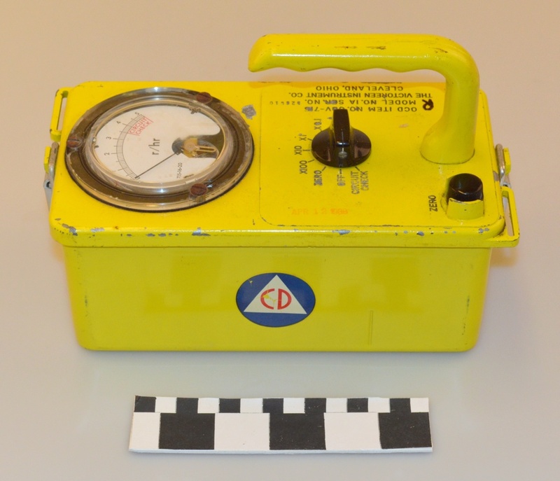 Image of a yellow radiation meter device with Civil Defense logo on the side.