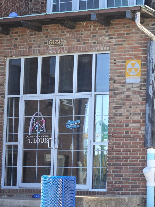 Close up view of fallout shelter sign by an entryway to the Gardenville School building.