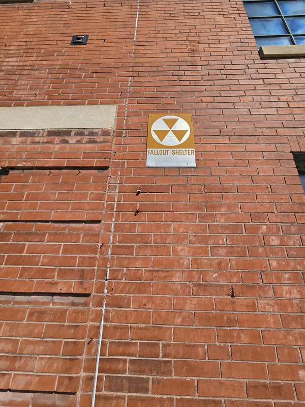 Close up view of fallout shelter sign on the KIPP School building.