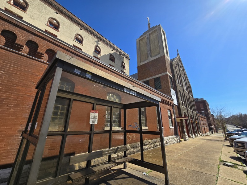 Wide view of St. Joseph church, with bus shelter in foreground.