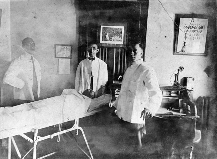 Three Unidentified Men Surrounding a Cadaver