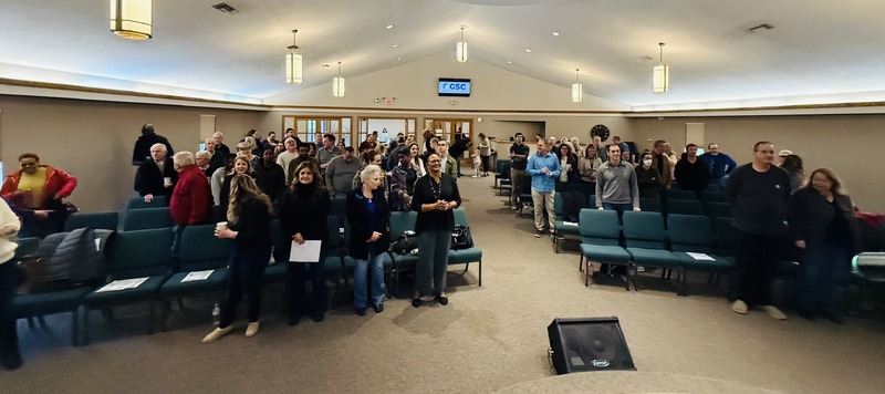 Wide view photograph of congregation before the start of St Charles' region's first official service in new building
