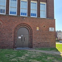 View of a fallout shelter sign near an entryway to the Sigel School building.