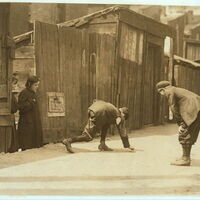 "Red St. Clair" and chum shooting craps in front of Murphy's Branch at 11:00 A.M. Thursday May 5th, a school day. Red is boss of the gang here. The girls hang around and watch the boys, skip rope with them, etc. St. Louis, Mo. Location: St. Louis, Missouri.