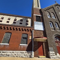 Close up of a fallout shelter sign near an entryway to the St. Joseph Church building.