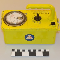 Image of a yellow radiation meter device with Civil Defense logo on the side.