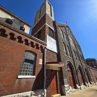 Front view of St. Joseph church building with fallout shelter sign near an entryway.