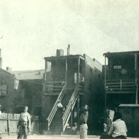 BOYS PLAYING IN THE BACK YARD OF HOMES THAT WOULD BE DESTROYED IN ORDER TO BUILD CARR SQUARE VILLAGE