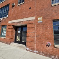 View of KIPP School building side entryway with fallout shelter sign next to it.