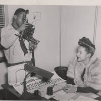 African-American Woman at Desk Being Photographed