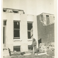 WOMAN IN FRONT OF TORNADO DAMAGED HOME
