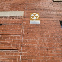 Close up view of fallout shelter sign on the KIPP School building.