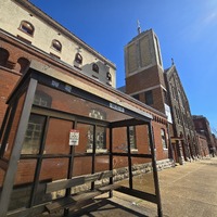 Wide view of St. Joseph church, with bus shelter in foreground.