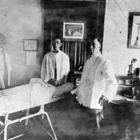 Three Unidentified Men Surrounding a Cadaver