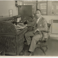 PRINCIPAL CLARENCE T. HUNTER SEATED AT HIS DESK